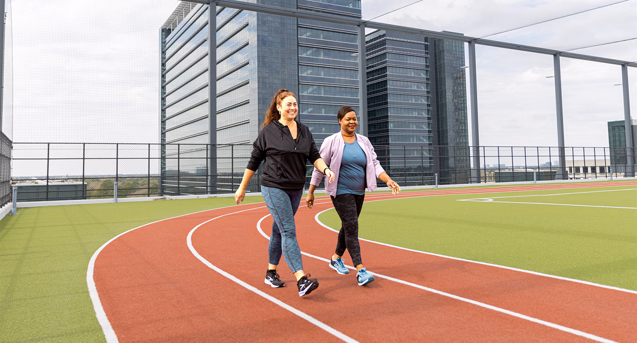 Two female workers walking around the track